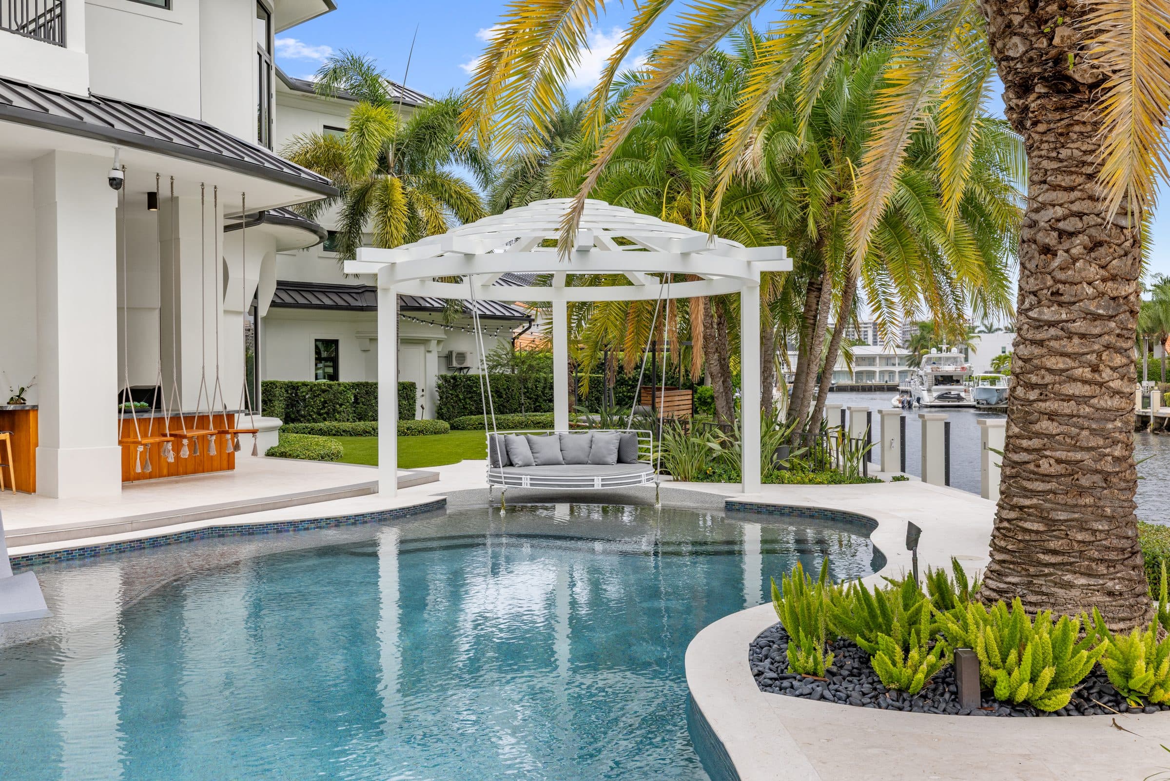 Covered outdoor lounge with stone fireplace and rattan seating