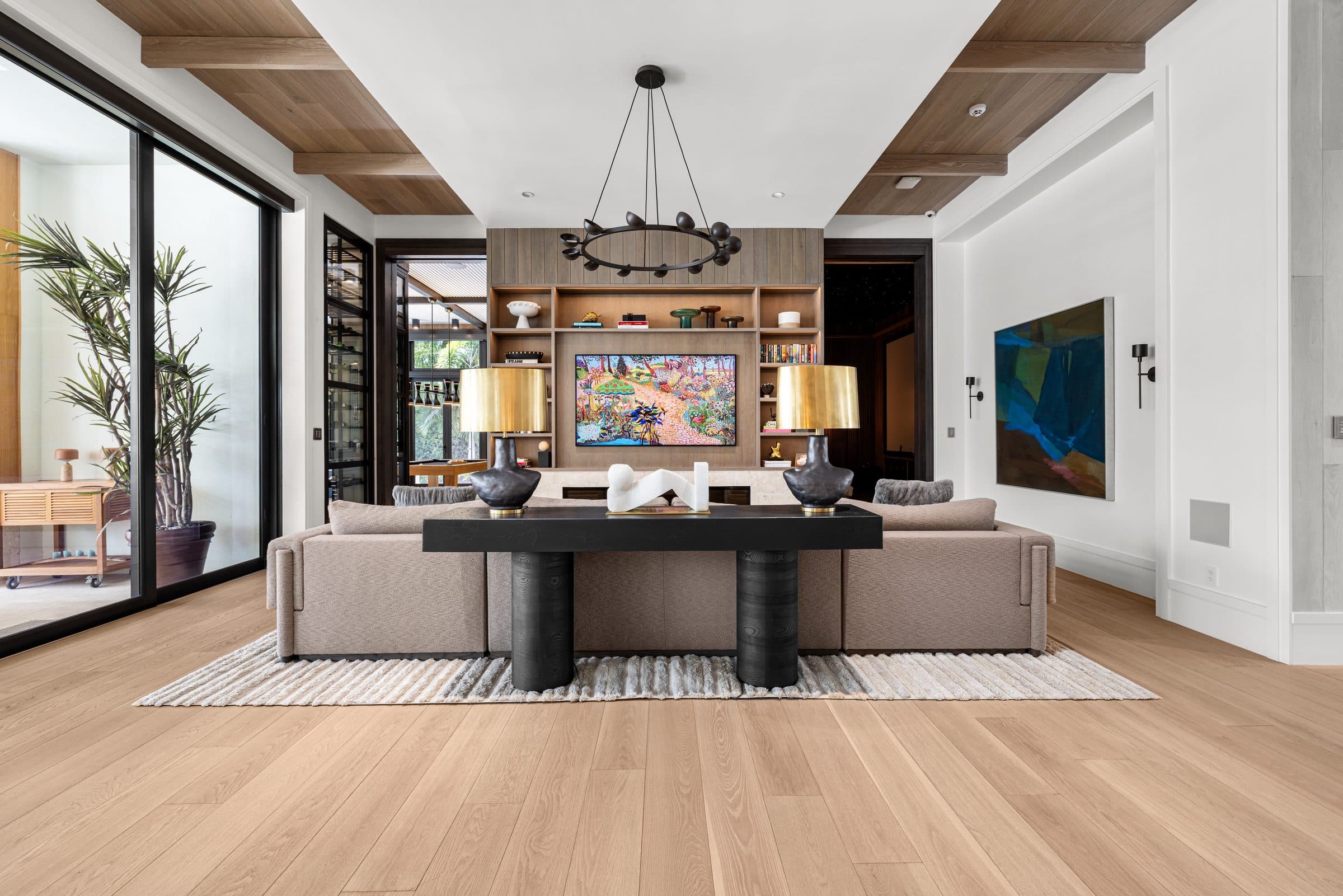 Living room with sectional sofa, entertainment wall, and hardwood floors